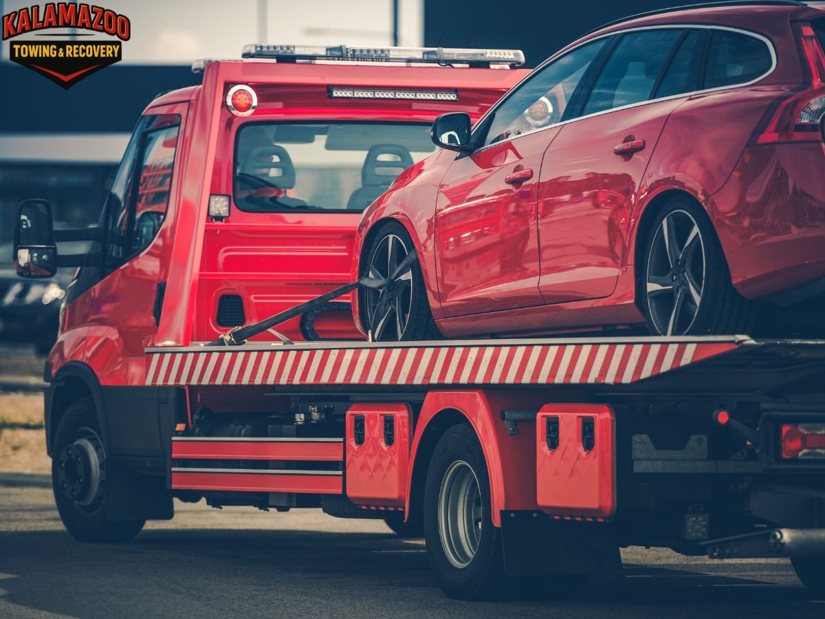 Tow truck winching a car from a snowy ditch near Kalamazoo MI